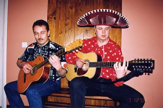Divi dziedātāji ar ģitārām, viens sombrero cepurē